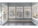 Bright sunroom featuring many windows and a door with outdoor views, hardwood flooring and cool gray walls at 505 Hay Hill Ln. # B, Myrtle Beach, SC 29579