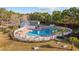 A beautiful community pool area with a white fence, palm trees, lounge chairs and mature landscaping at 509 Hillsborough Dr., Conway, SC 29526