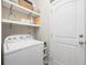 Convenient laundry area features a washer and dryer next to storage shelves and a nearby door at 509 Hillsborough Dr., Conway, SC 29526