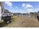 Wide shot of a backyard overlooking a lake, featuring a grill and fire pit at 517 Antebellum Ln., Georgetown, SC 29440