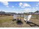 Backyard featuring an iron fence, lake view, and fire pit with Adirondack chairs at 517 Antebellum Ln., Georgetown, SC 29440