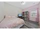 Cozy bedroom featuring pink walls, hardwood floors, a window, and a dollhouse at 517 Antebellum Ln., Georgetown, SC 29440