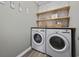 Well-organized laundry room with washer, dryer, open shelves, and stylish wallpaper at 517 Antebellum Ln., Georgetown, SC 29440