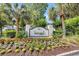 Community entrance sign surrounded by landscaping and American flags at 5801 Oyster Catcher Dr. # 1623, North Myrtle Beach, SC 29582