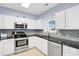 The kitchen features white cabinets, stainless steel appliances, and a mosaic backsplash at 5801 Oyster Catcher Dr. # 1623, North Myrtle Beach, SC 29582