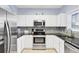 The kitchen features white cabinets, stainless steel appliances, and black countertops at 5801 Oyster Catcher Dr. # 1623, North Myrtle Beach, SC 29582