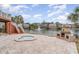 Backyard with a hot tub and stone fireplace overlooking a picturesque lake with a fountain at 601 Tradewind Ct., North Myrtle Beach, SC 29582