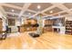 Open basement space featuring a kitchenette, stone columns, hardwood floors, and recessed lighting at 601 Tradewind Ct., North Myrtle Beach, SC 29582