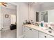 Bathroom featuring a single vanity with a sink, a framed mirror, and an open doorway to an adjoining bedroom at 601 Tradewind Ct., North Myrtle Beach, SC 29582