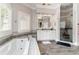 Bright bathroom with a soaking tub, a glass enclosed shower, and a double vanity with a large framed mirror at 601 Tradewind Ct., North Myrtle Beach, SC 29582