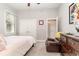 Cozy bedroom with neutral paint, a ceiling fan, a leather chair, and double closets by a window at 601 Tradewind Ct., North Myrtle Beach, SC 29582