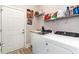 Laundry room with a washer, a dryer, shelving with cleaning supplies, and decorative artwork at 601 Tradewind Ct., North Myrtle Beach, SC 29582