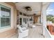 Inviting covered porch with tile flooring, ceiling fans, and comfortable white wicker furniture for relaxing outdoors at 601 Tradewind Ct., North Myrtle Beach, SC 29582
