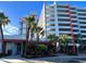 Attractive building exterior with lush landscaping, palm trees, and a Starbucks Coffee at 7200 Ocean Blvd. N # 1059, Myrtle Beach, SC 29572