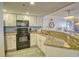 Well-equipped kitchen featuring granite countertops, white cabinetry, and modern appliances at 7200 Ocean Blvd. N # 1059, Myrtle Beach, SC 29572