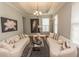 Bright living room featuring elegant sofas, a decorative chandelier, and large windows for natural light at 962 Henry James Dr., Myrtle Beach, SC 29579