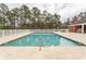 Community swimming pool surrounded by a white fence and mature trees at 962 Henry James Dr., Myrtle Beach, SC 29579