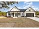 Charming white farmhouse with black accents, inviting front porch, and two-car garage at 1052 Merritt Rd, Conway, SC 29526
