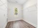 Bright laundry room with wood floors, wire shelves, and natural light from the window at 1052 Merritt Rd, Conway, SC 29526