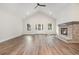 Spacious living room featuring a vaulted ceiling, brick fireplace, and wood-look floors at 1052 Merritt Rd, Conway, SC 29526