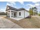 View of home's rear exterior, concrete patio, screened-in porch and light-colored siding at 1052 Merritt Rd, Conway, SC 29526
