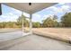 View of spacious screened-in porch and backyard with mature trees and blue skies at 1052 Merritt Rd, Conway, SC 29526