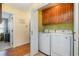 Laundry room showcasing a modern washer and dryer set with overhead wood cabinets at 115 Blue Pride Dr., Loris, SC 29569