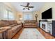 Cozy living room featuring a fireplace, hardwood floors, and a ceiling fan at 115 Blue Pride Dr., Loris, SC 29569