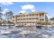 Exterior shot of condominiums with multiple levels and balconies, surrounded by well-maintained landscaping and parking at 1230 St. George Ln. # F, Myrtle Beach, SC 29588