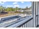View of a community pool with cover, surrounded by a fence and trees, as seen from a balcony at 1230 St. George Ln. # F, Myrtle Beach, SC 29588