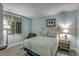 Comfortable bedroom with light blue walls, two side tables with lamps, and a padded chair underneath the window at 3000 Ocean Blvd. # 1209, Myrtle Beach, SC 29577