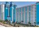 Bright blue and white high-rise hotel exterior, showing the colorful architecture and surrounding palm trees at 3000 Ocean Blvd. # 1209, Myrtle Beach, SC 29577