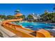 Outdoor swimming pool with orange slide and a view of nearby residences and palm trees at 3000 Ocean Blvd. # 1209, Myrtle Beach, SC 29577