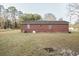 Back of the brick home featuring windows and set on a spacious lot at 3285 Della Rd., Longs, SC 29568