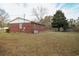 Back view of a charming single-story brick home and expansive backyard at 3285 Della Rd., Longs, SC 29568