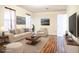 Staged living room featuring wood floors, neutral furniture, and ample natural light at 3285 Della Rd., Longs, SC 29568