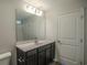 Bathroom featuring gray cabinets, single sink, large mirror, and a white door leading to the toilet/shower at 411 Lifestyle Court, Surfside Beach, SC 29575