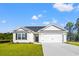 Charming single-story home featuring a two-car garage, manicured lawn, and classic vinyl siding at 411 Lifestyle Court, Surfside Beach, SC 29575