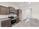 Kitchen with granite countertops, stainless appliances, wood cabinets, and stainless sink and faucet at 411 Lifestyle Court, Surfside Beach, SC 29575