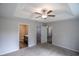 Spacious main bedroom featuring carpet, ceiling fan, tray ceiling, ensuite bath, and a walk-in closet at 411 Lifestyle Court, Surfside Beach, SC 29575