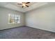 Comfortable bedroom featuring tray ceilings, a ceiling fan, a large window, and plush carpeting at 415 Lifestyle Court, Surfside Beach, SC 29575