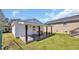 Backyard with grass, a house, and a shed with a porch and bench at 4938 Trooper Ln., Loris, SC 29569