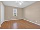 Neutral bedroom featuring hardwood floors, base trim and a window with blinds at 4938 Trooper Ln., Loris, SC 29569