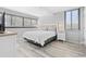 Bright bedroom featuring a queen bed, bedside tables, lamps and large windows with blinds at 601 Mitchell Dr. # 203, Myrtle Beach, SC 29577