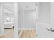 Bright hallway leading to a bedroom, featuring light wood floors, white trim, and fresh gray paint at 601 Mitchell Dr. # 203, Myrtle Beach, SC 29577