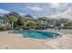 Outdoor swimming pool with lounge chairs and shaded seating area surrounded by palm trees at 601 Mitchell Dr. # 203, Myrtle Beach, SC 29577
