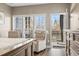 Bright bedroom featuring a comfy chair, three windows with natural light, and a door leading to a balcony at 70 Addison Cottage Way # 121 & 32, Murrells Inlet, SC 29576