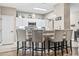 This spacious kitchen with white cabinetry, granite counters, and barstool seating overlooks the cozy dining area at 70 Addison Cottage Way # 121 & 32, Murrells Inlet, SC 29576
