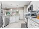 Bright kitchen with stainless steel appliances, white cabinets, granite countertops, and access to living area at 70 Addison Cottage Way # 121 & 32, Murrells Inlet, SC 29576
