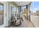 Relaxing screened porch with wicker chairs, ceiling fan, and green siding at 70 Addison Cottage Way # 121 & 32, Murrells Inlet, SC 29576